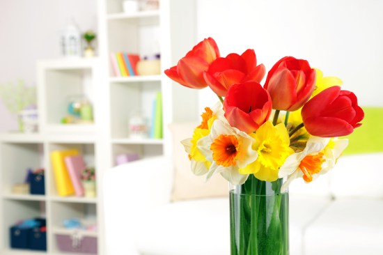 Beautiful spring flowers in vase on home interior background
