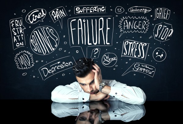 Young depressed businessman sitting under white drawn trouble th